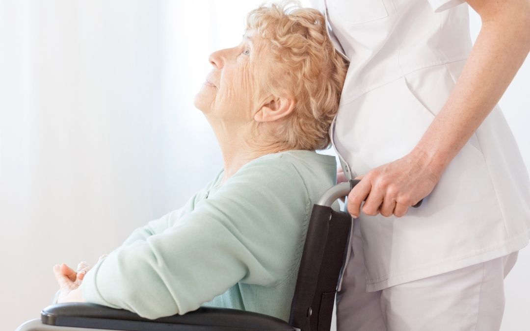 Senior woman with nurse in wheel chair