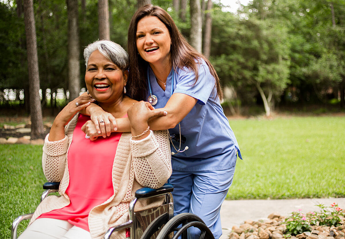 Nurse Providing Senior Living Services to Woman in Wheelchair